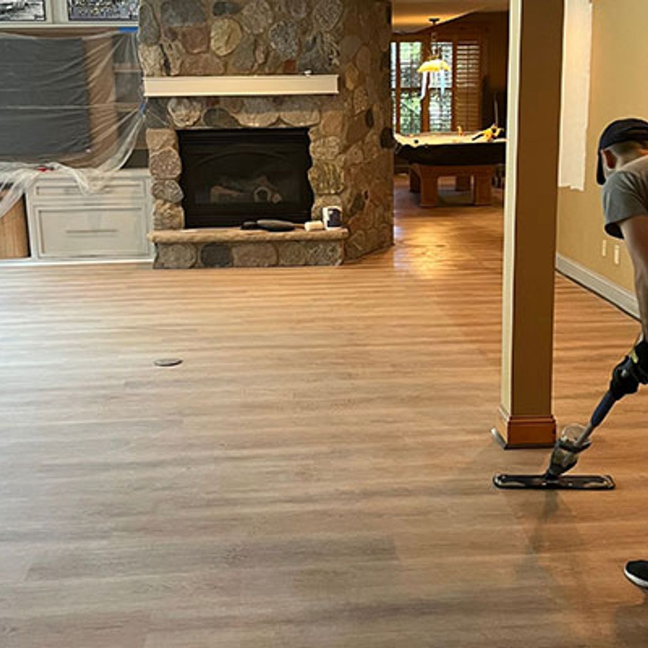 worker cleaning new wooden flooring