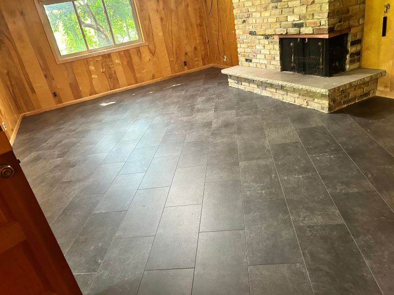 dark tiled basement space with a fireplace