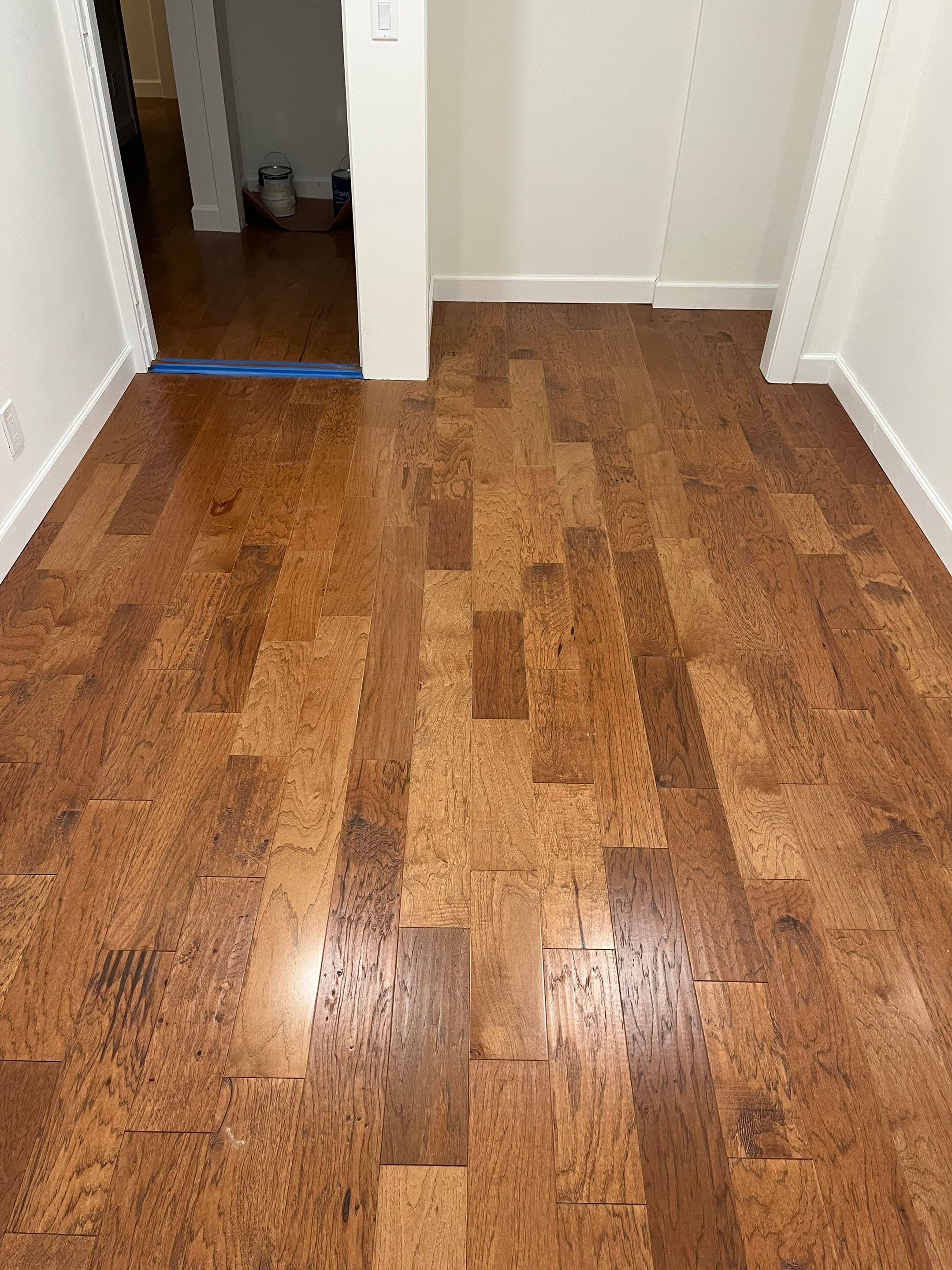 warm laminate flooring in an empty room and open closet