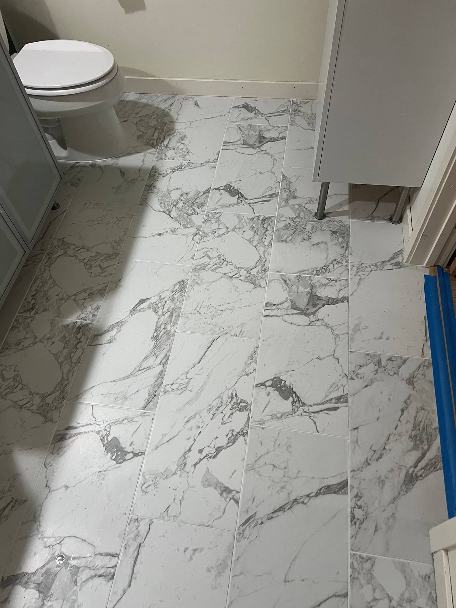 light tile flooring in an open room with an entertainment vcenter